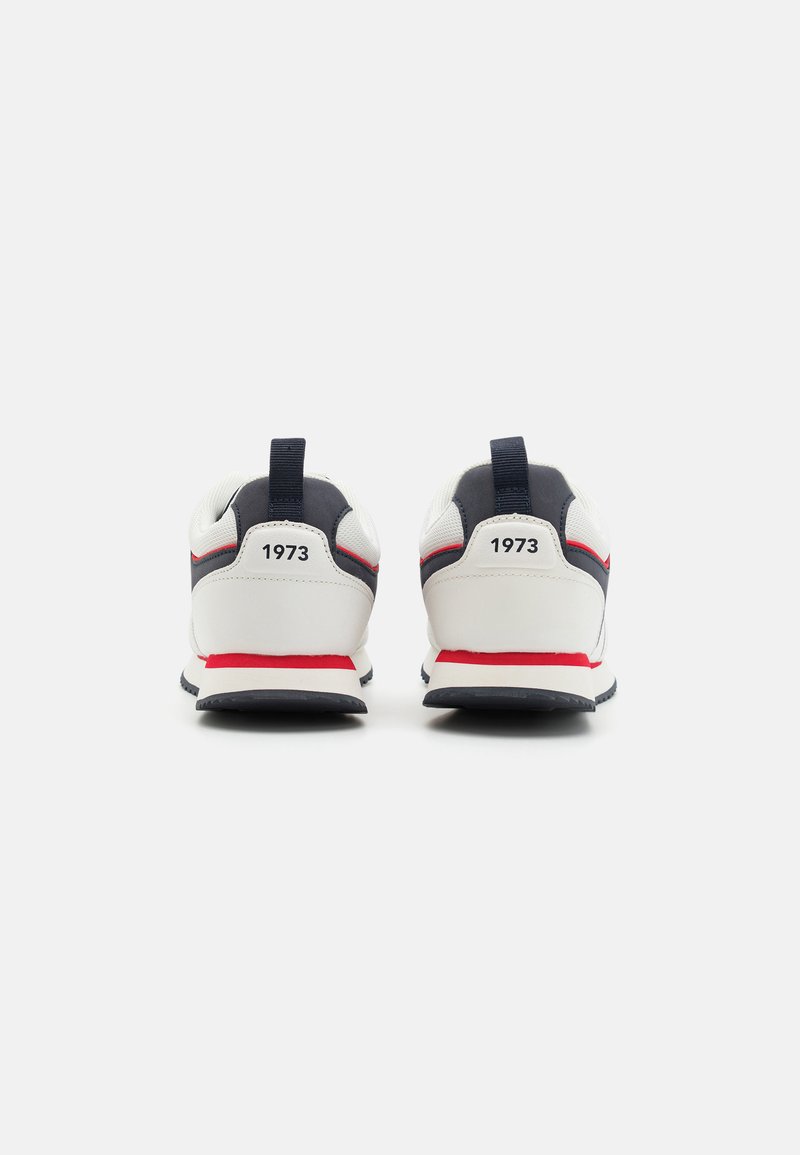 Weiße und marineblaue Sneaker mit roten Akzenten. Die Rückansicht zeigt einen gepolsterten Kragen und eine Zuglasche. Auf beiden Fersen befindet sich die Aufschrift "1973". Gummisohle.