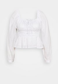 Bílá dlouhá halenka s dlouhými rukávy a čtvercovým výstřihem, nařaseným předním dílem, řaseným pasem, detaily zavazování vpředu a rozšířeným peplum spodním lemem.