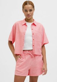 Rood en wit gestreept shirt met korte mouwen en knoopsluiting, gecombineerd met bijpassende shorts met een elastische tailleband en zijzakken.