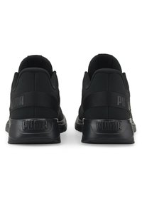 Czarne sportowe buty z syntetycznej cholewki. Posiadają grubą piętę, wyściełany kołnierz oraz elastyczny pasek z logo "PUMA" z tyłu.