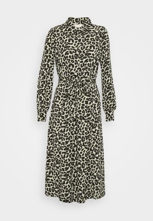 Robe chemise midi à manches longues avec imprimé léopard noir et blanc, boutonnage sur le devant, col et ceinture nouée à la taille.