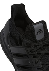 Chaussure de sport noire avec une tige en maille, un col de cheville texturé, un design à trois bandes et une semelle en caoutchouc. Détail de logo subtil sur le talon.