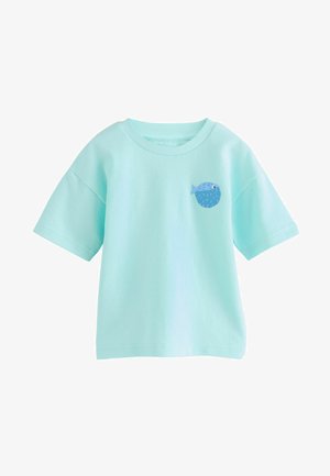 T-shirt en coton bleu clair avec des manches courtes et un col rond, orné d'un petit motif de poisson illustré sur la poitrine.