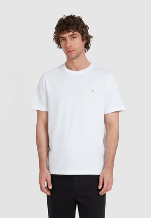 Witte katoenen T-shirt met een ronde halslijn en korte mouwen. Heeft een klein oranje logo op de linkerborst. Glad textuur.