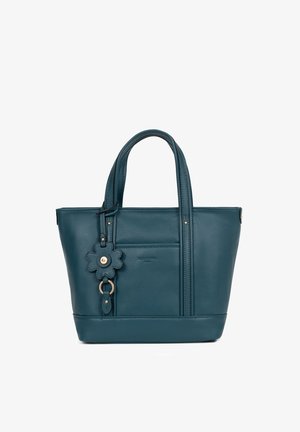 Petrolkleurige leren handtas met dubbele handvaten, een voorvak en een sleutelhanger in de vorm van een bloem die aan één handvat hangt.