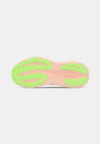 Shoe outsole featuring a pink base with green traction patterns, ridges, and a curved design for enhanced grip.
