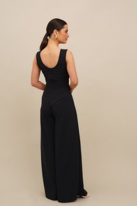 Σκούρο μπλε ολόσωμη φόρμα χωρίς μανίκια με εφαρμοστό μπούστο, φαρδιά παντελόνια και στρογγυλή πλάτη με κρυφό φερμουάρ. Ομαλή υφή υφάσματος.