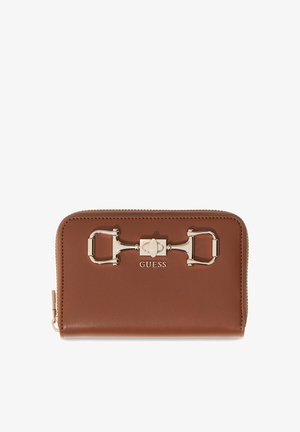 Cartera marrón de cuero con cierre alrededor, detalle de estribo en tono dorado y logo GUESS en el frente.