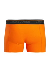 Oranžni bombažni boksarji s črnim elastičnim pasom, na sprednji strani pa je v krepki pisavi napisano ime blagovne znamke "JACK & JONES".
