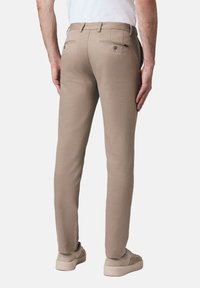 Beżowe spodnie slim fit o gładkiej teksturze materiału, z dwiema tylnymi kieszeniami zapinanymi na guziki oraz paskiem w pasie.
