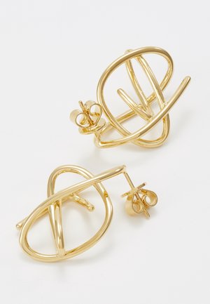 Paar moderne Ohrstecker aus goldfarbenem Metall mit abstrakten überlappenden Oval- und Stabformen auf weißem Hintergrund.