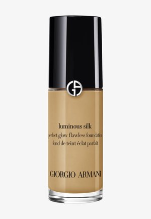 Flacon de fond de teint Giorgio Armani Luminous Silk avec un bouchon noir, fond de teint liquide beige à l’intérieur et logo de la marque sur le devant.