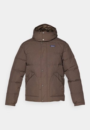 Veste isolante brune avec un col haut et une capuche, des boutons-pression, des poches latérales et une doublure matelassée. Texture douce et lisse.