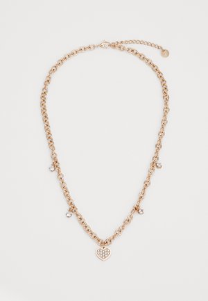 Zlatým tónovaná reťazová náhrdelník s príveskom v tvare srdca, ktorý má zdobený dizajn a malé kryštály umiestnené na reťazi.