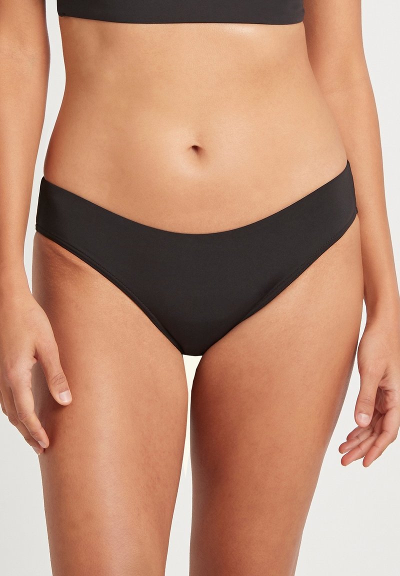 Czarne bikini o niskim stanie wykonane z gładkiego materiału, charakteryzujące się minimalnym zakryciem i prostymi liniami, bez widocznych elementów metalowych.