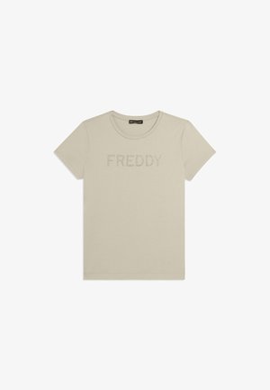 Camiseta beige de manga corta con cuello redondo y "FREDDY" escrito con pequeñas tachuelas en el pecho.
