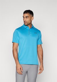 Camisa polo azul claro de tejido texturizado con un cuello a juego. Presenta un pequeño logo negro de Under Armour en el lado izquierdo del pecho.