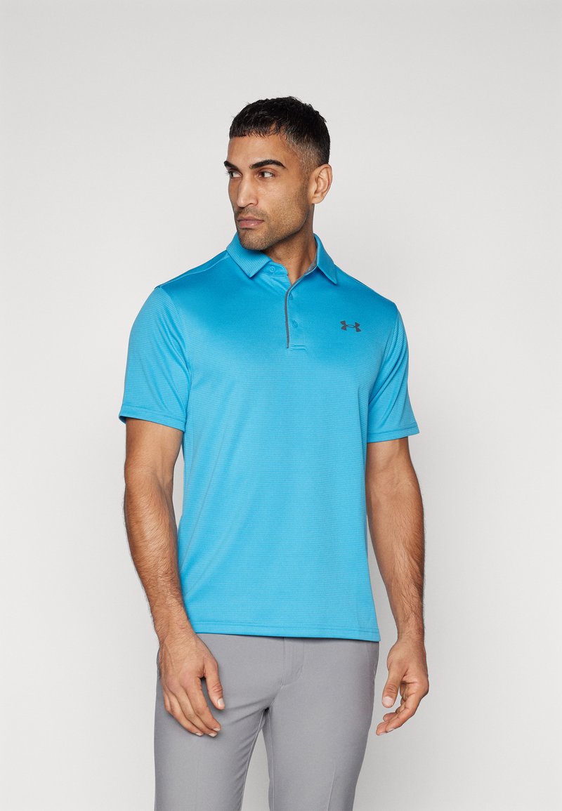 Camisa polo azul claro de tejido texturizado con un cuello a juego. Presenta un pequeño logo negro de Under Armour en el lado izquierdo del pecho.