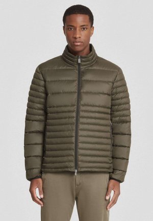 Giubbotto imbottito verde oliva con colletto alto, design a baffi orizzontali, zip frontale e polsini elasticizzati. Tessuto liscio e lucido.