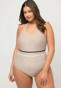 Beige étone-piece badedragt med tekstureret overflade, halterneck-design og kontrastfarvede marineblå og hvide horisontale striber i taljen.