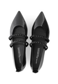 Schwarze Lacklederschuhe mit spitzer Zehenform, ausgestattet mit zwei sich kreuzenden Riemen, die mit schwarzen Perlen verziert sind, und einem glatten Innenfutter.