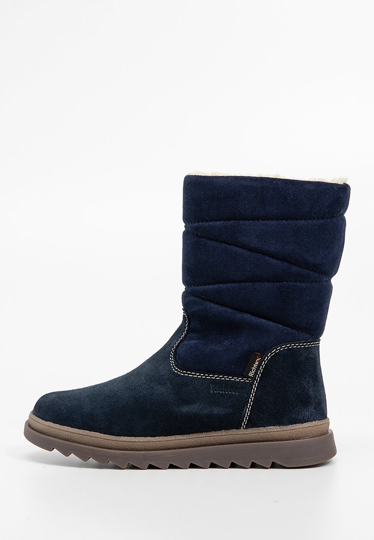 Marineblaue Wildlederstiefel mit einem gefalteten Schaft, weichem Futter und einer strukturierten braunen Gummisohle mit Zickzackmuster. Weiße Nähte setzen Akzente.