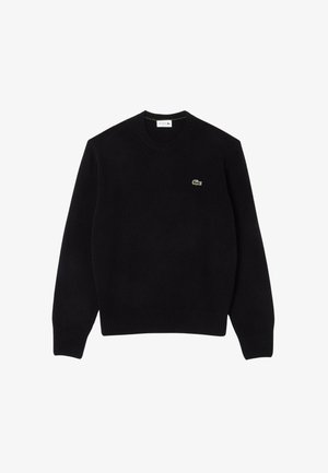 Maglione nero a maglia con collo rotondo, polsini e orlo a coste, caratterizzato da un piccolo logo di coccodrillo verde sul lato sinistro del petto. Texture morbida.