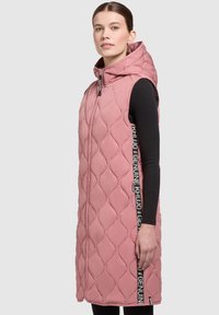 Quilted ärmellose Weste in Hellrosa, mit hohem Kragen, frontseitigem Reißverschluss, seitlichen Logo-Akzenten und knielangem Design.