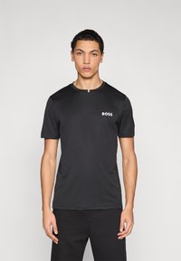 Melnā īsroku T-krekls ar apaļu izgriezumu un mazu baltu "BOSS" logotipu kreisajā krūšu daļā. Gluda, viegla auduma materiāls.