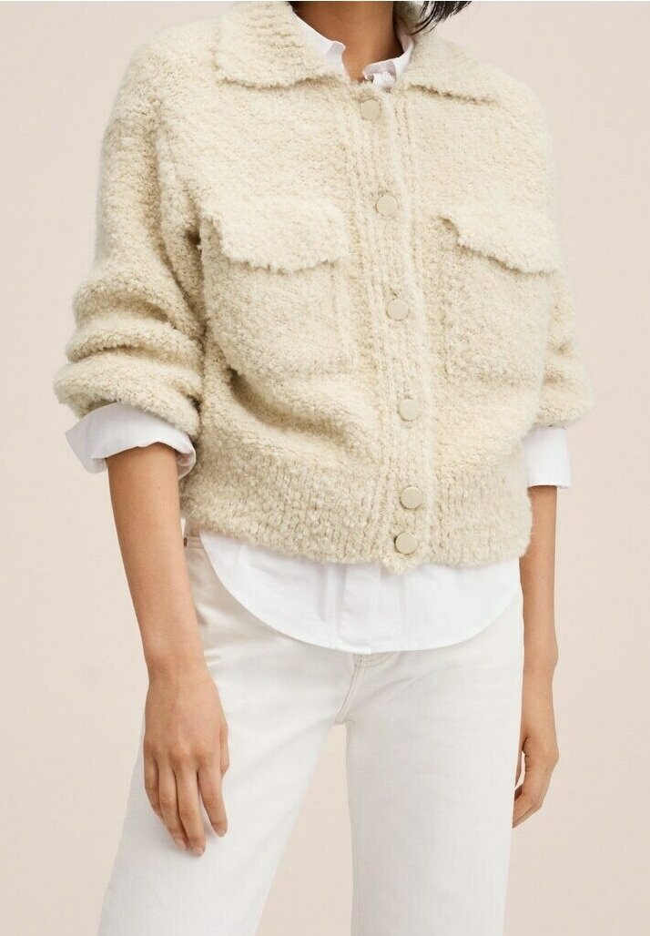 Beige bouclé cardigan met een kraag, vooraan met knoopsluiting en twee borstzakken. Lange mouwen met opgerolde manchetten, textiel met structuur.
