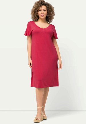 Robe rouge courte avec un décolleté en V et des manches volantées. Fabriquée dans un tissu lisse, elle présente une coupe décontractée et arrive au niveau du genou.