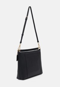 Czarna skórzana torba na ramię z regulowanym paskiem, złotymi elementami oraz detalami z zamkiem, zaprezentowana na białym tle.