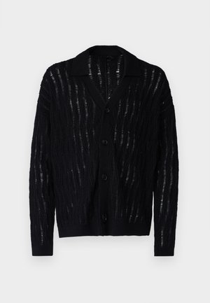Svart cardigan med en teksturert bølgemønster og V-hals. Har fem knapper foran og ribbbestrikkede mansjetter. Lett materiale.