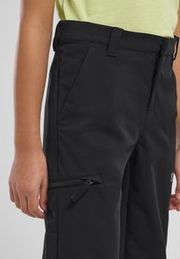 Pantalons de sport noirs en tissu lisse, dotés de poches latérales zippées, d'une taille régulière et d'une coupe épurée.