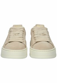 Smėlio spalvos zomšos platforminiai sportbačiai su storomis baltomis padomis ir plačiomis smėlio spalvos raištelėmis, matomi iš priekio prieš baltą foną.