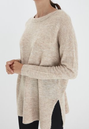 Maglione beige a maglia con una vestibilità rilassata, caratterizzato da maniche lunghe, polsini a costine, scollo rotondo e spacchi laterali per una maggiore libertà di movimento.