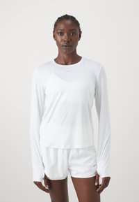 White long-sleeve athletic top with a round neckline and lightweight fabric. Features a logo on the chest and breathable design.
