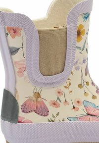 Botte en caoutchouc à motif floral avec une base crème, des accents lavande, un bord supérieur texturé et un intérieur textile beige. Présente des papillons et des motifs floraux.