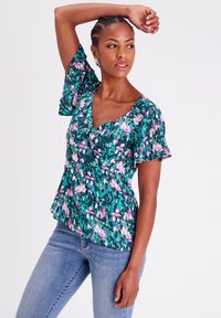 Blumenbluse mit kurzen Glockenärmeln, petrolfarbenem Hintergrund, rosa und weißen Mustern. Weicher Stoff mit gerafftem Kragen und ausgestelltem Saum.