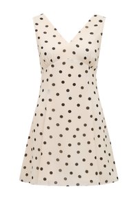 Sleeveless cream mini dress with black polka dots and a V-neckline, featuring a fitted bust and flared skirt.