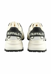 Balti ir balti sportbačiai su tekstūruotu viršumi, stambiu padu ir "BUFFALO" logotipu ant kulno dirželio, pasižymintys lygiu paviršiumi ir tvirtu dizainu.