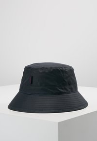 Black bucket hat made of water-resistant fabric. Features a wide brim and a stitched band. Small logo tag visible on the side.