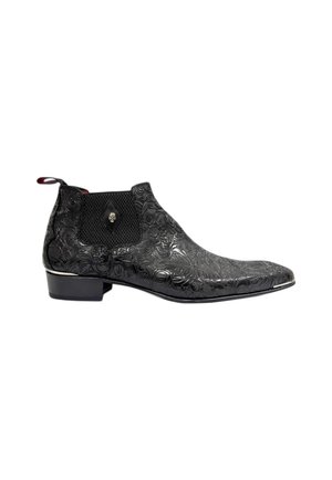 Bota de tobillo de cuero negro con diseño floral en relieve, panel lateral elástico texturizado y acento cromado a lo largo de la suela. Tacón bajo apilado.