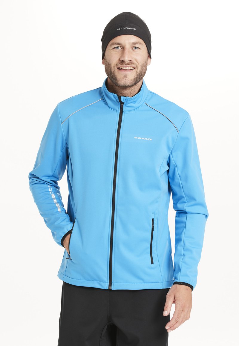 Lysblå zip-up jakke med høj krave, sort lynlås og kontraststrik. To sidelommer og lange ærmer.