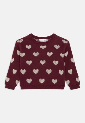 Pull en maille bordeaux à manches longues avec des motifs de cœurs beige disposés de manière régulière sur le devant et les manches.