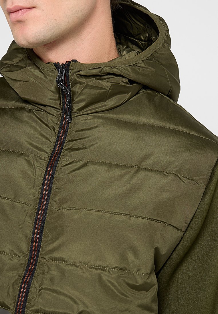 Oliwkowa kurtka z kapturem o pikowanym wzorze, z zamkiem błyskawicznym w pomarańczowym akcentem i gładką fakturą.