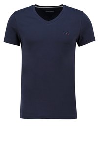 Camiseta de algodón lisa de color azul marino, con mangas cortas y escote en V. Presenta un pequeño logo en el pecho y un diseño de corte clásico.