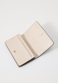 Beige leren portemonnee met een gestructureerd oppervlak, voorzien van een interieur met kaartsleuven en een drukknoopsluiting. Geïmpregneerd logo zichtbaar.