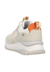 Zapatilla gris y blanca con una parte superior de ante texturizado, acentos naranjas, suela acolchada y una lengüeta con patrón en el talón.