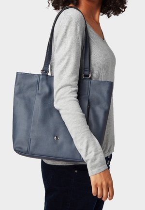 Bolso tote de cuero azul con una superficie texturada, dos asas largas y un diseño elegante. Presenta un pequeño acento metálico en la parte inferior.
